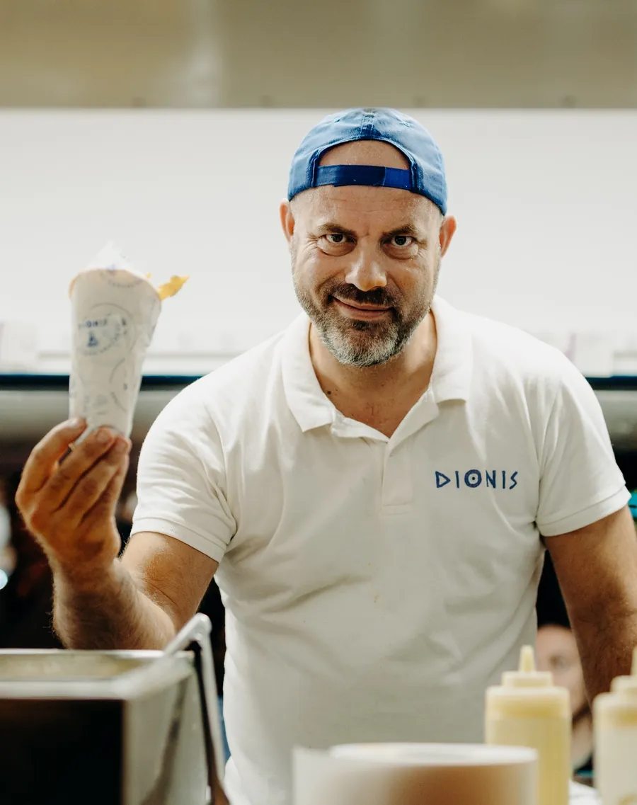 Le patron de Dionis, souriant, une pita dans la main
